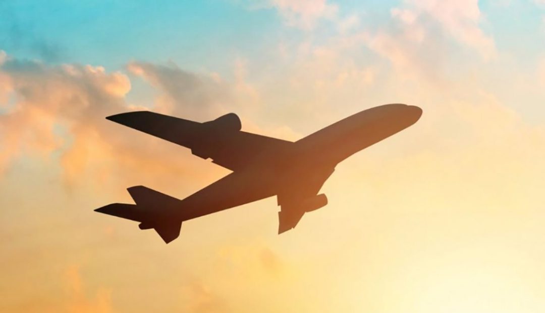 Plane travelling through sunset sky